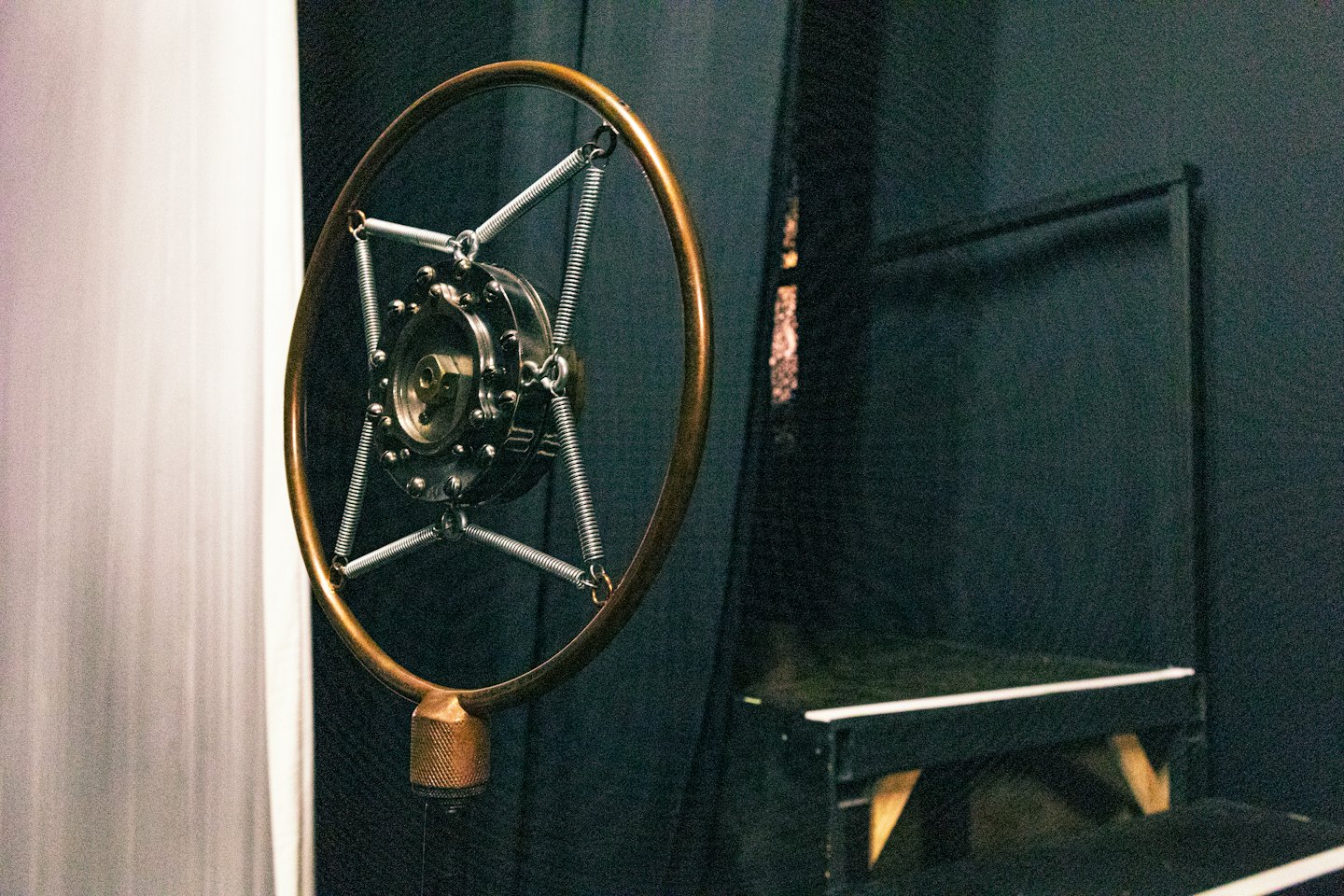 Vintage brass microphone suspended in a recording studio.