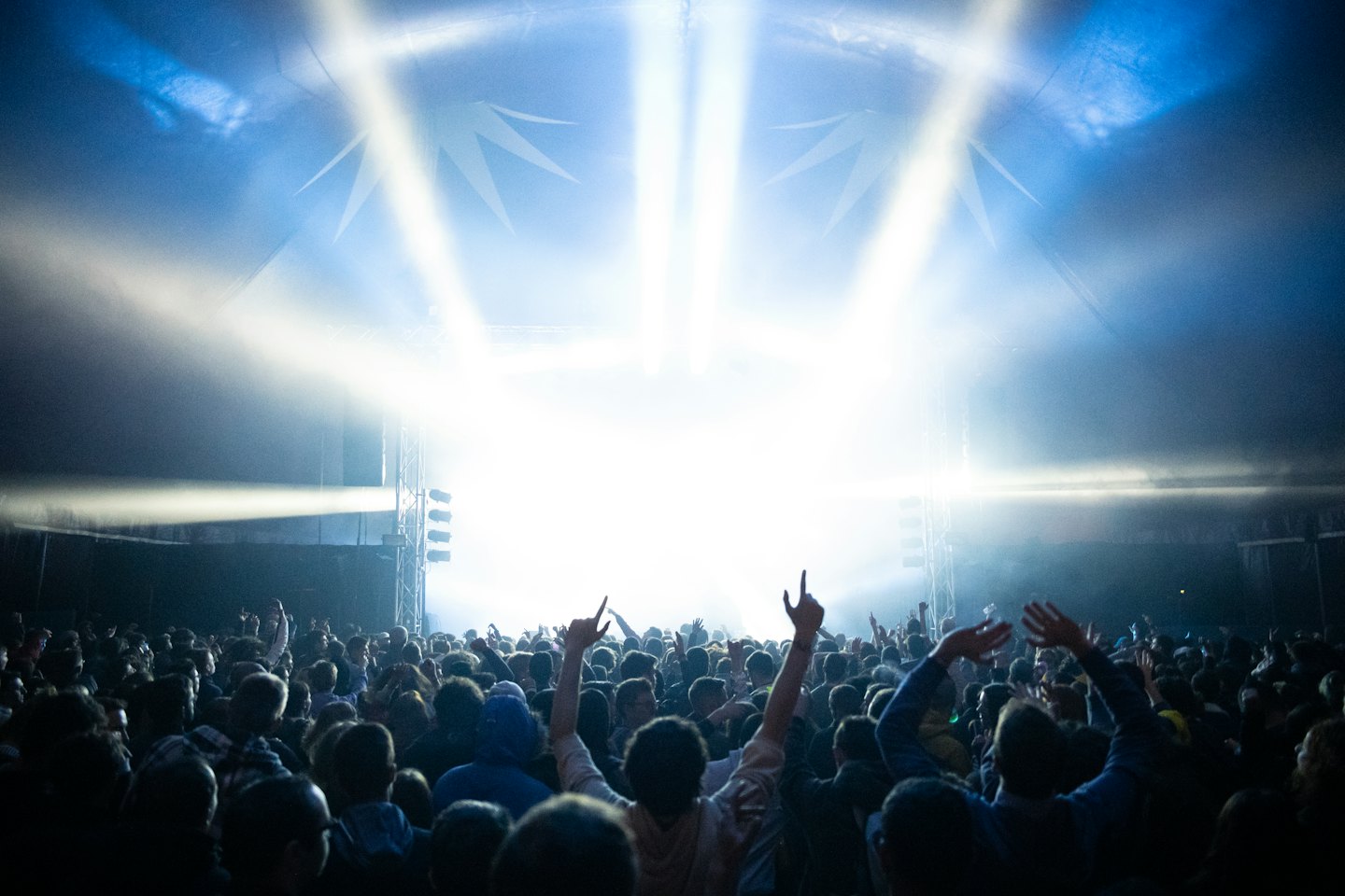 Crowd raises hands in excitement at a concert.
